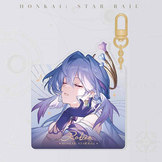 Honkai: Star Rail keychain showcases the character Robin, with her serene, closed-eye portrait printed on acrylic, paired with a gold clasp and chain.