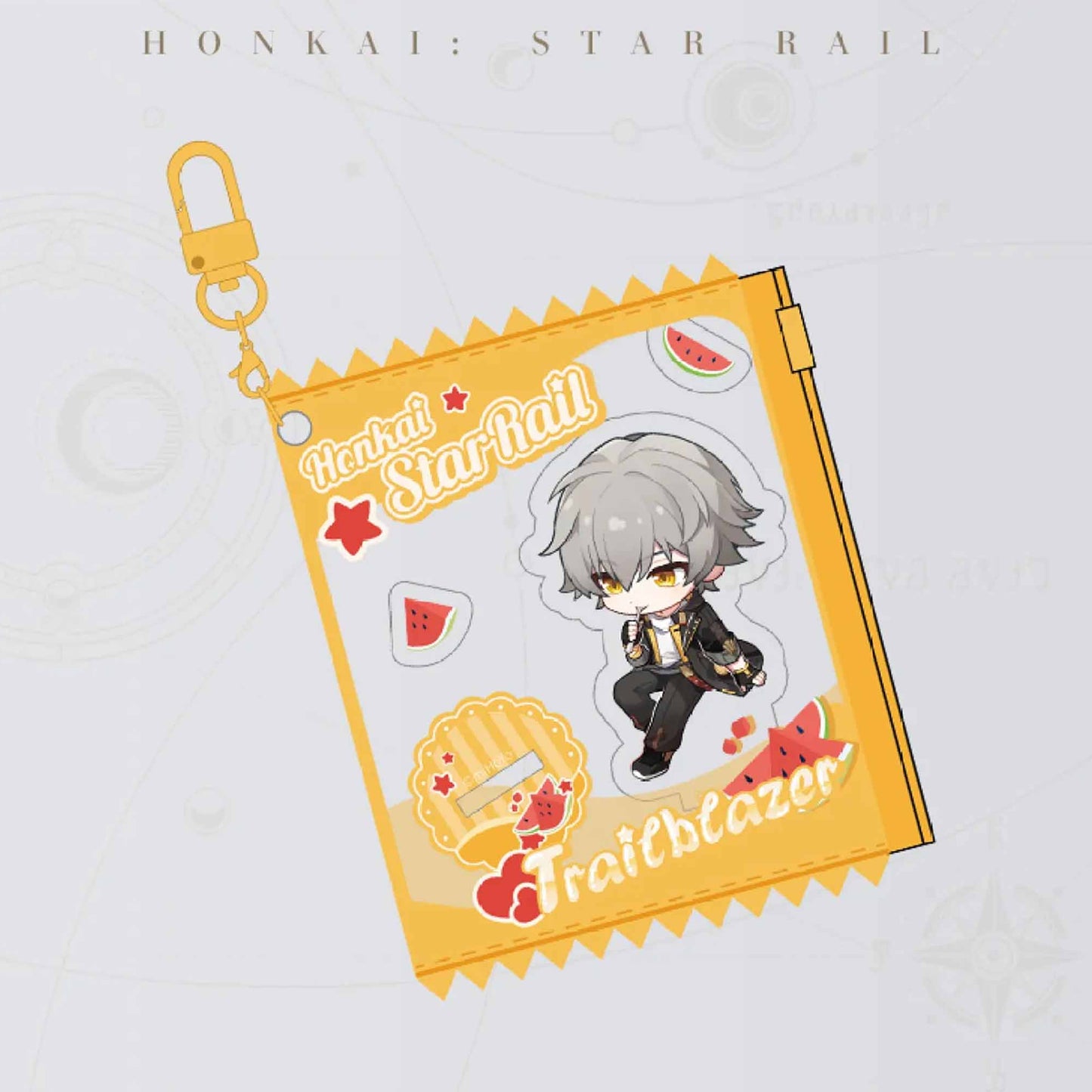 A close-up of the male Trailblazer acrylic charm, featuring his chibi art in a bright yellow, watermelon-themed frame with a gold metal clasp.