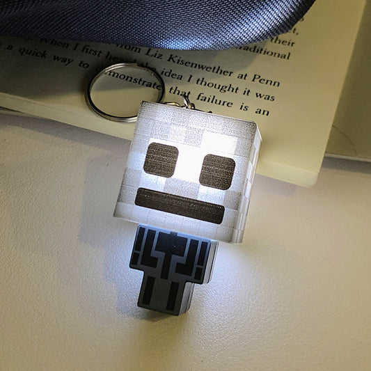 Pixel-style Skeleton Archer glow keychain featuring a white glowing light, inspired by classic Minecraft mobs.