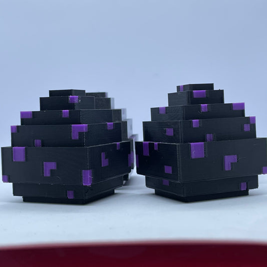Pair of Minecraft dragon egg figures, blocky black and purple plastic desk decorations