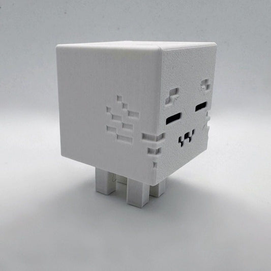 Minecraft Ghast desktop decoration, white plastic cube figurine with pixel-style face, inspired by the Ghast mob