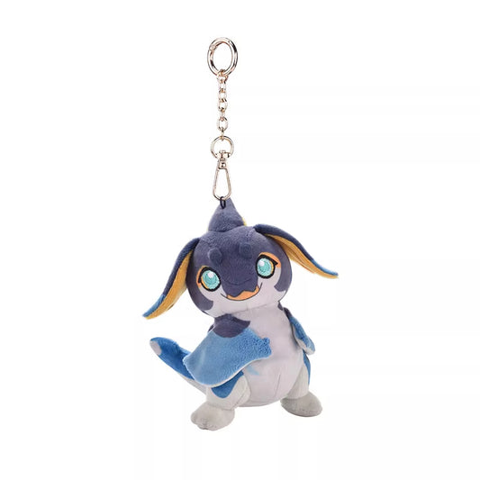 This is a cute plush keychain featuring a small, dragon-like creature. It has a blue and white body with yellow inner ears and large, expressive green eyes. The plush has a cheerful expression, with a small smile and a playful stance.