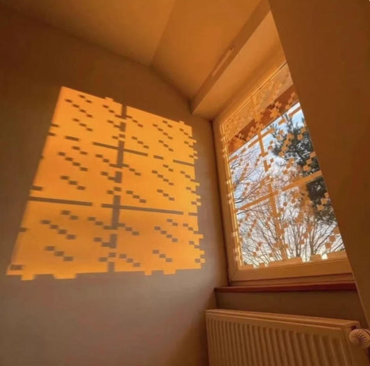 Sunlight passes through MC-style static cling stickers, casting a pixelated pattern onto the wall. A warm, golden glow brings the Minecraft aesthetic to life in the room.
