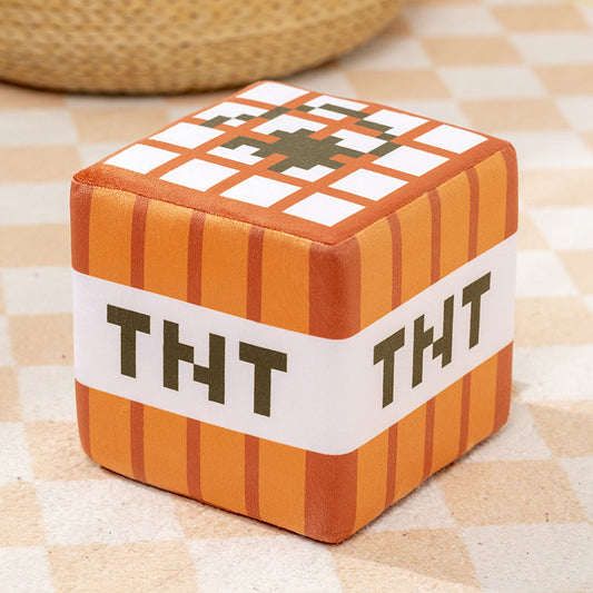 Minecraft TNT block plush pillow with soft foam rubber filling, cube-shaped design, displayed on a checkered floor for gaming room decor.