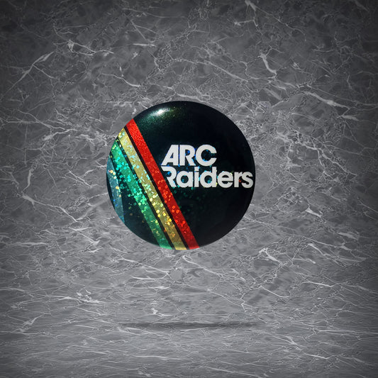 Round ARC Raiders pin button featuring the white text logo with retro green, yellow, and red stripes on a black background, finished with a holographic glitter effect.