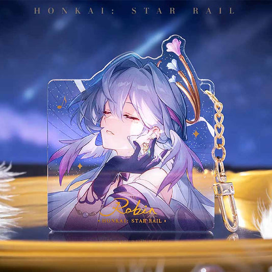 Honkai: Star Rail keychain showcases the character Robin, with her serene, closed-eye portrait printed on acrylic, paired with a gold clasp and chain.