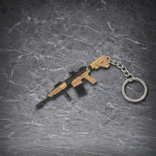 This is a detailed, miniature assault rifle keychain with a tan and black color scheme, realistic features, and a metal chain ring, perfect for gun enthusiasts and collectors.