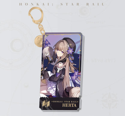 This Honkai: Star Rail acrylic keychain features Herta with her puppet companion, with a golden clasp and chain, set against a deep purple background with purple flowers.