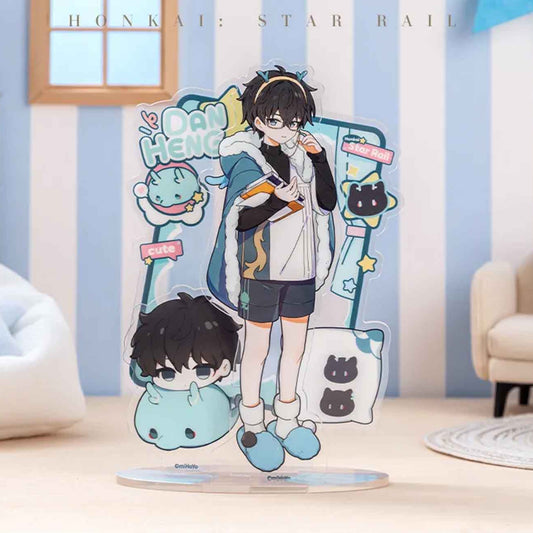 A single acrylic stand of Dan Heng in a cozy, casual outfit, paired with a chibi head figure and a cute blue plush creature, framed by playful “cute” and “DAN HENG” text.