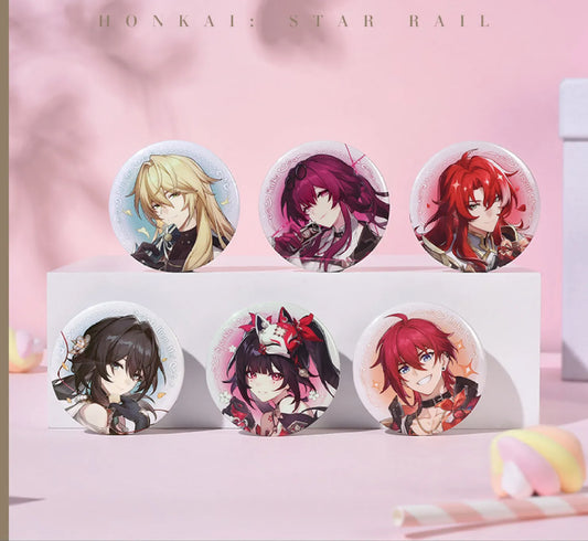 A display of six character pins from the Cosmic Candy House series, arranged on a white tiered stand against a soft pink backdrop. Each pin features vivid anime-style artwork with a shimmering iridescent white glitter base.
