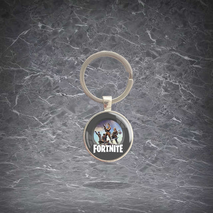 Round Fortnite-themed keychain featuring character artwork and the game logo, set in a shiny metal frame with a sturdy split ring. Lightweight, scratch-resistant pendant for keys, backpacks, and bags. Ideal for fans to show off their love for the game.