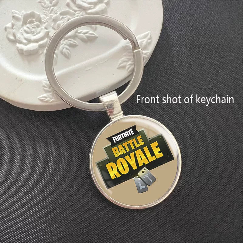 Fortnite Battle Royale keychain with the iconic game logo on a warm-toned background, set in a polished silver frame with a scratch-resistant dome. Perfect for keys or backpacks.