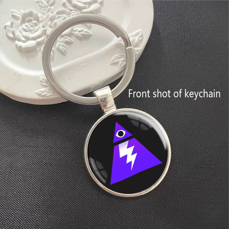 Round Fortnite Storm-themed keychain with a vibrant purple triangle and lightning bolt design, set in a polished silver metal frame. Features a scratch-resistant glass dome cover and sturdy split ring, ideal for keys, backpacks, or bags. A sleek collectible for game fans.