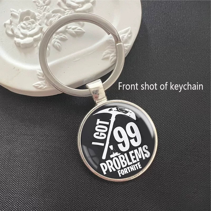 Fortnite-themed keychain featuring the “I Got 99 Problems” text with a pickaxe graphic. Set in a polished silver frame with a scratch-resistant dome, perfect for keys or backpacks.