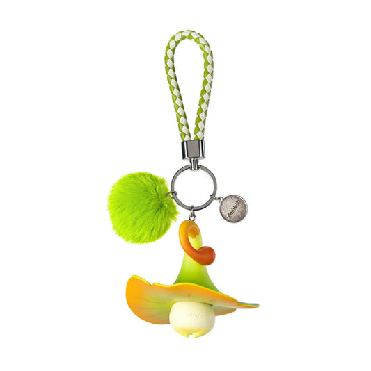 This Genshin Impact Aranara keychain is shown from the back, featuring its rounded orange-green mushroom cap, a fluffy lime pom-pom, and a braided wrist strap for easy carrying.