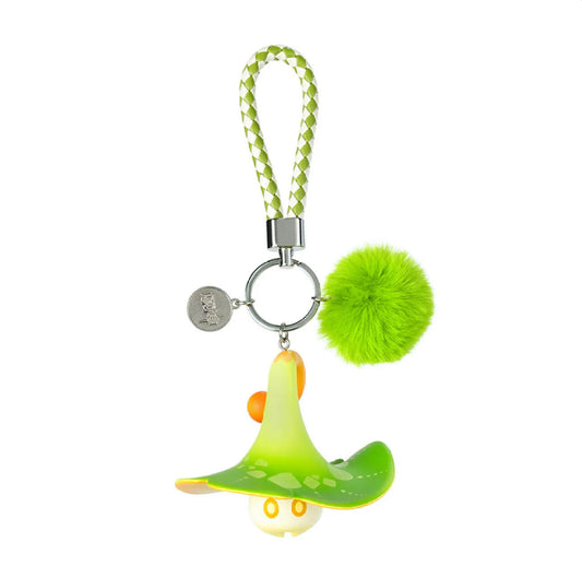 The front view reveals the Aranara’s cute, expressive face beneath its vibrant green mushroom cap, paired with a fuzzy pom-pom and a green-and-white braided strap.