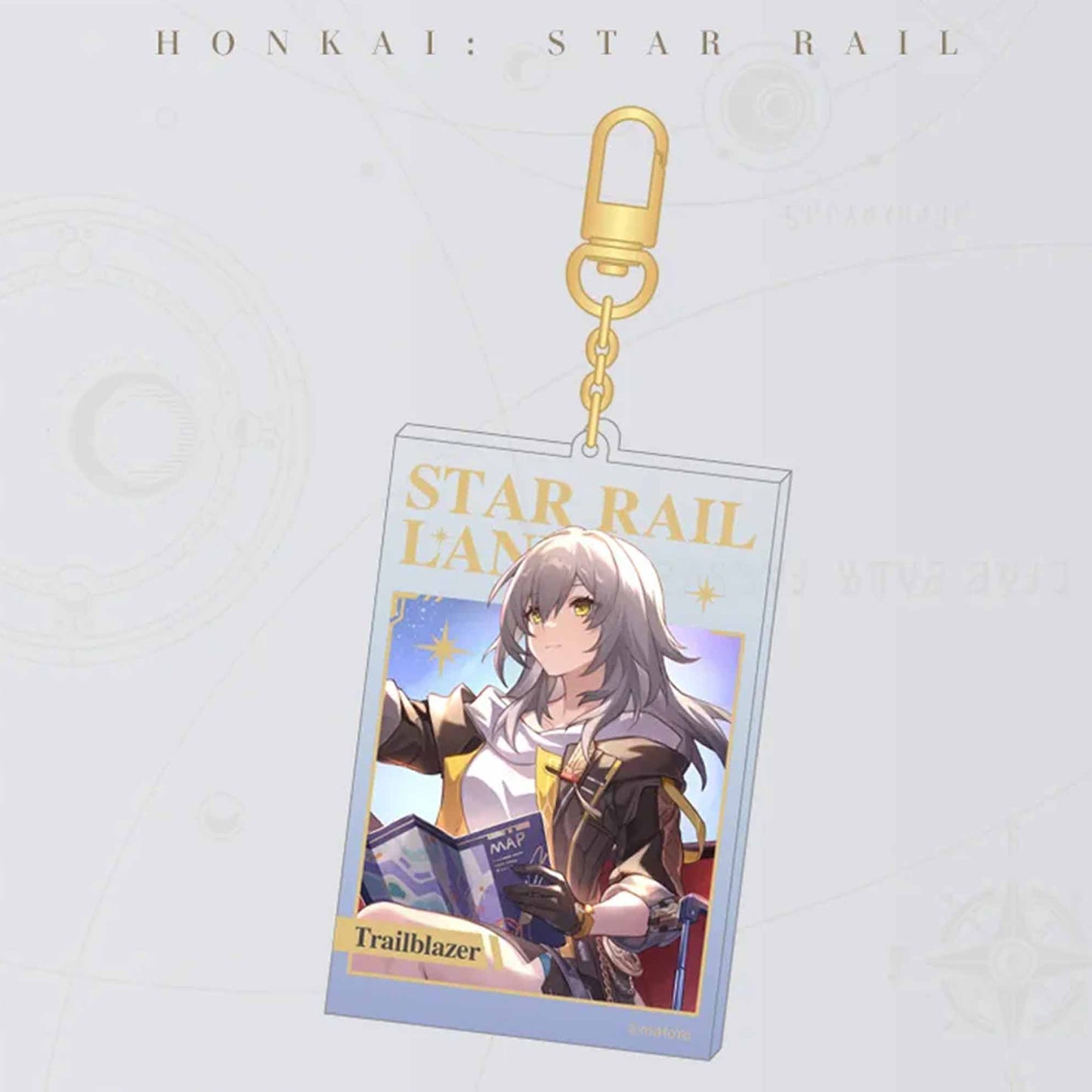 A single Honkai: Star Rail acrylic card keychain with a gold carabiner. It showcases the female Trailblazer, with “STAR RAIL LANE” in gold foil and the character’s name at the bottom.