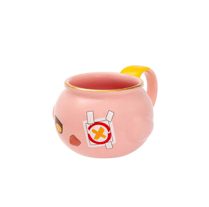 The side view reveals the mug’s smooth pink ceramic body, the character’s bandage detail, and the contrasting yellow-and-pink handle, emphasizing its cute, collectible appeal.