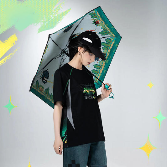 The umbrella is held at an angle, showcasing its lightweight design and the pixelated jungle artwork on the canopy, paired with a Kinich-themed black T-shirt for a coordinated look.
