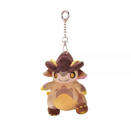 This is a cute plush keychain featuring a small, dragon-like creature. It has a brown and beige body with yellow accents on its ears, paws, and underbelly. The plush has large, expressive orange eyes and a cheerful smile.