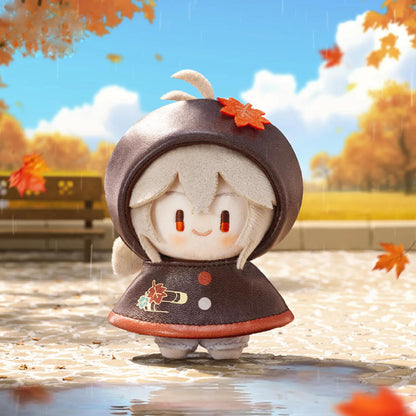 This plush charm features Kaedehara Kazuha from Genshin Impact, wearing a deep brown raincoat with a maple-leaf hood. He stands in an autumnal, rain-slicked park, his gentle expression capturing his calm, poetic nature.