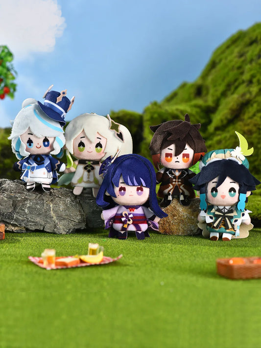 A group of adorable Genshin Impact Carnival Gathering Series finger puppet keychains, featuring characters like Venti, Zhongli, and Raiden Shogun, posed together on a sunny grassy hill with a blue sky and green hills in the background