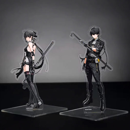 Two acrylic stands of the Male and Female Wanderers from Wuthering Waves, featuring their sleek black tactical outfits and signature polearms against a neutral grey background.