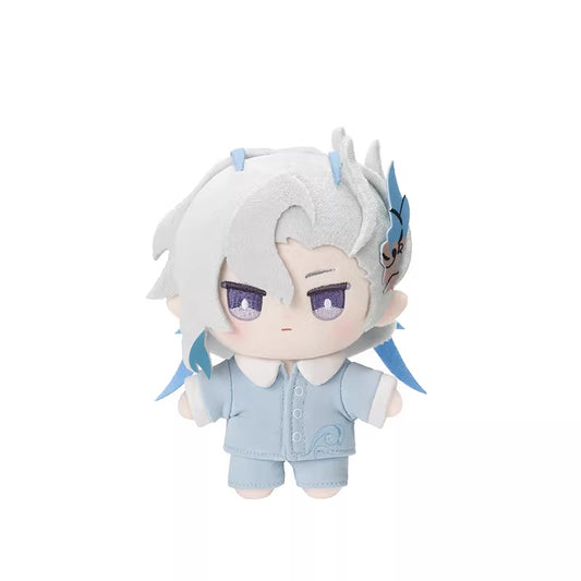 It has silver hair with blue accents, including a blue accessory on the side. The doll features large, expressive purple eyes and a small, neutral mouth. It is dressed in a light blue pajama set with white trim and a decorative swirl on the shirt.