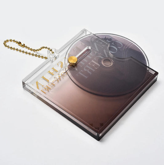  The clear acrylic case is secured by a gold-colored screw top, allowing the inner CD disc to be removed or displayed separately. 